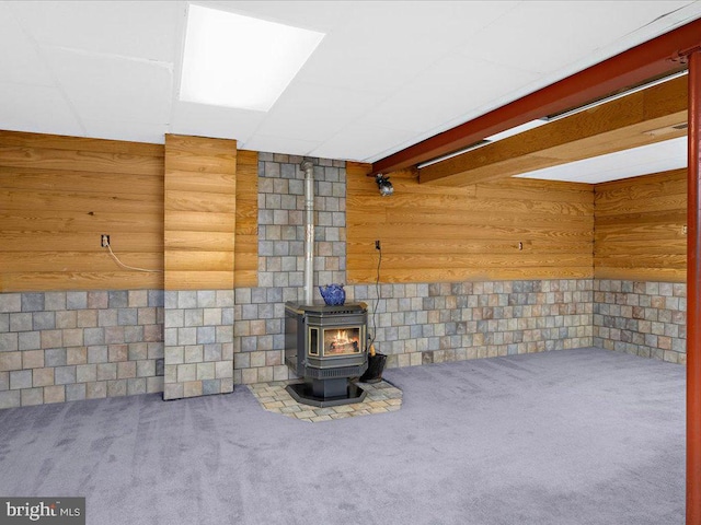 details with wooden walls, a wood stove, and carpet floors