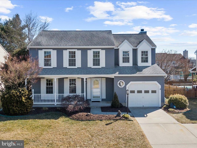 traditional-style home featuring fence, driveway, a porch, a front lawn, and a garage