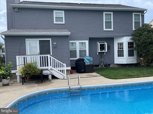 back of property featuring an outdoor pool, a chimney, and a patio