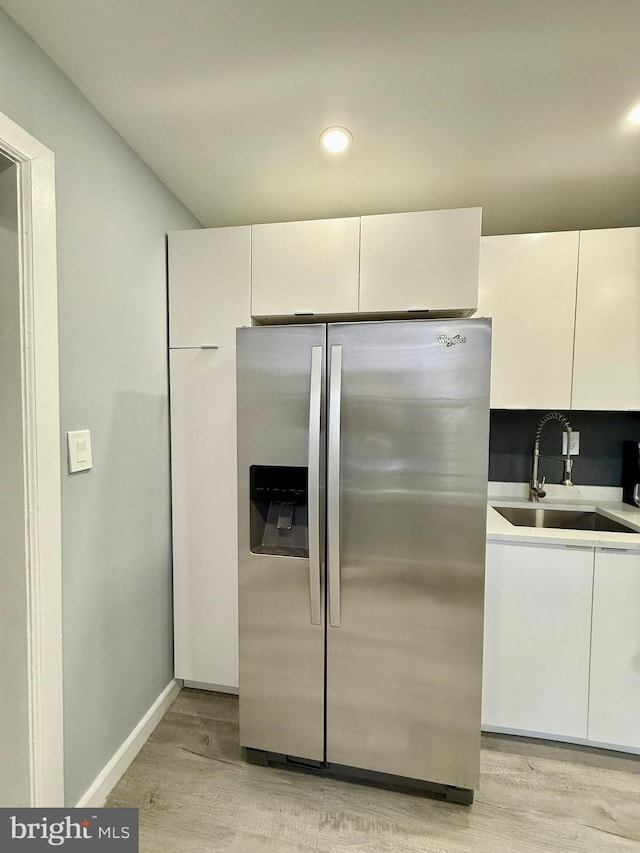 kitchen featuring sink, white cabinets, and stainless steel refrigerator with ice dispenser