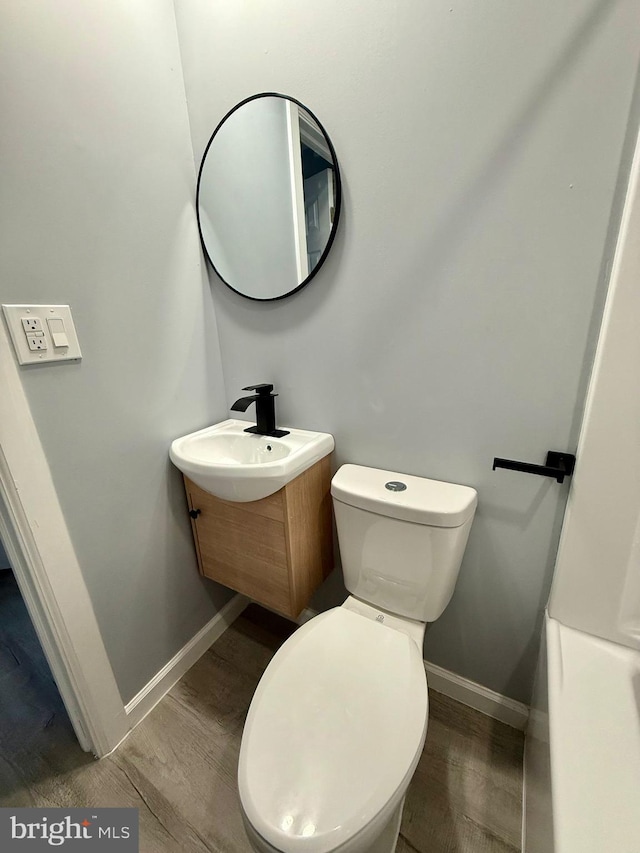 bathroom with hardwood / wood-style flooring, vanity, and toilet