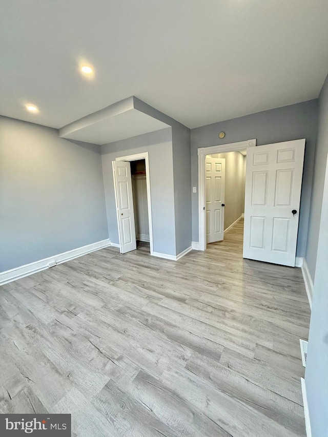 unfurnished bedroom featuring light wood-type flooring and a closet