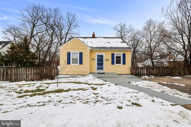 bungalow-style house with fence and a chimney