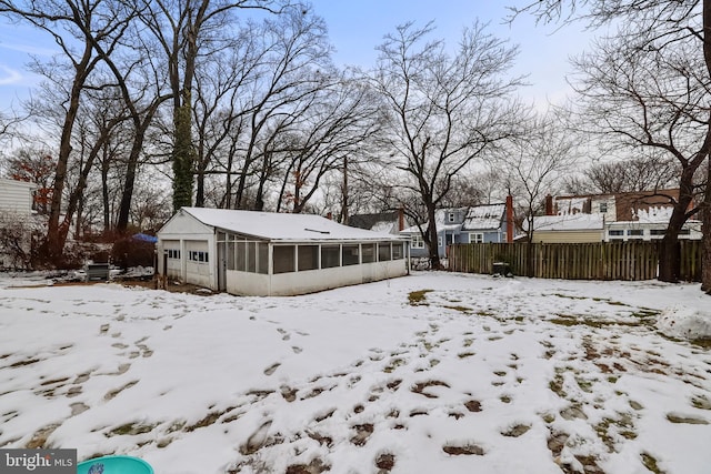 snowy yard with a sunroom