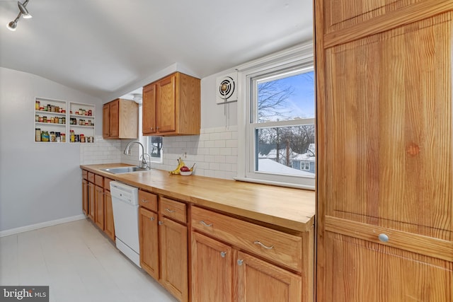 kitchen with vaulted ceiling, dishwasher, sink, and backsplash