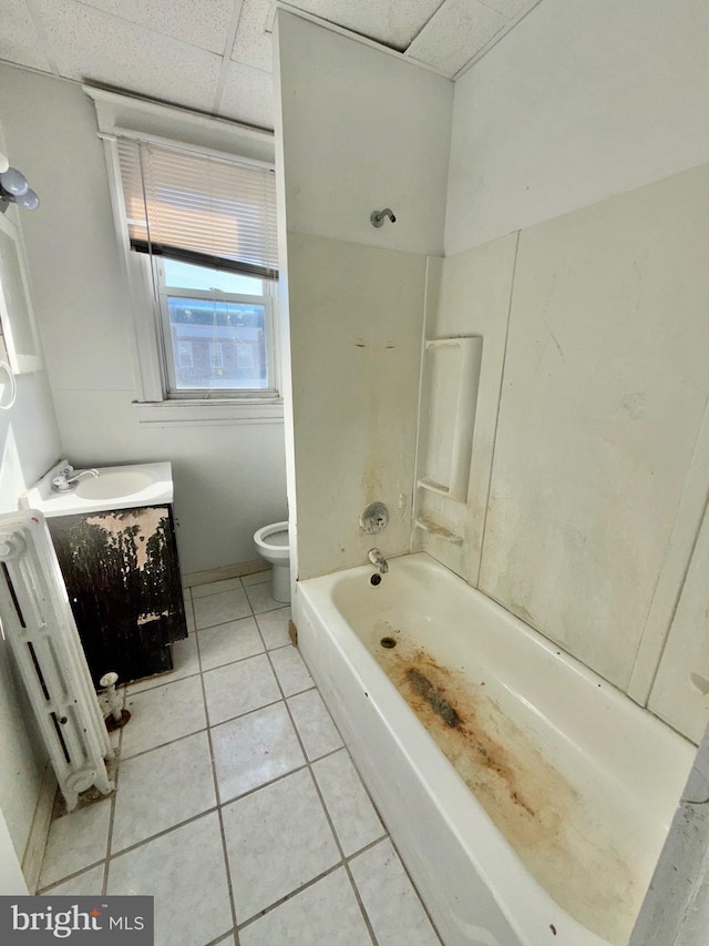 full bathroom featuring a paneled ceiling, shower / bathing tub combination, tile patterned flooring, vanity, and toilet