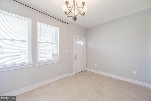 entrance foyer featuring baseboards and a chandelier