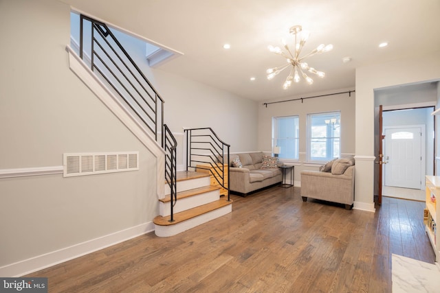 living area featuring stairway, wood-type flooring, visible vents, and baseboards