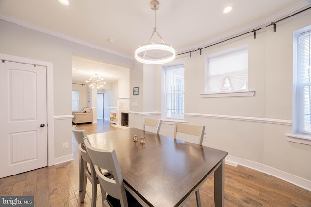 dining area featuring crown molding, baseboards, wood finished floors, and recessed lighting