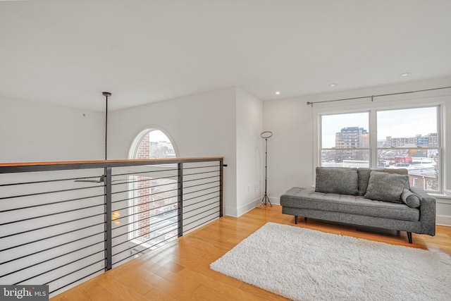 living area with a view of city, baseboards, recessed lighting, and wood finished floors