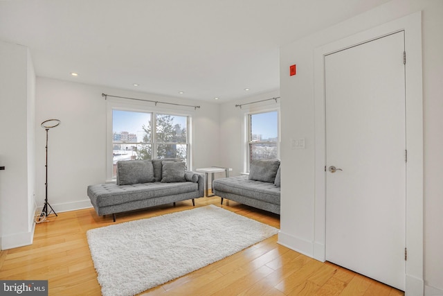 living area featuring light wood-type flooring, baseboards, and recessed lighting