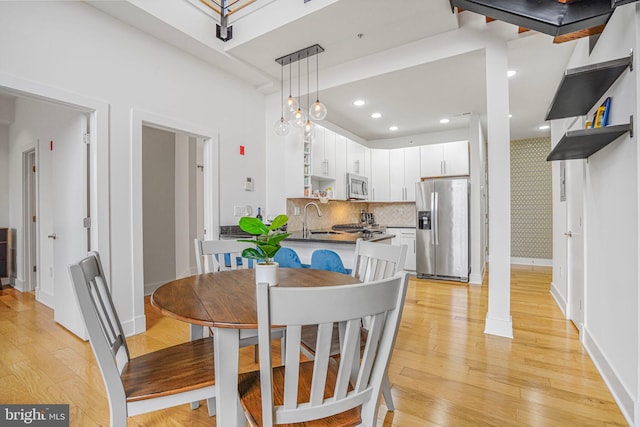 dining area featuring recessed lighting, light wood-style flooring, and baseboards