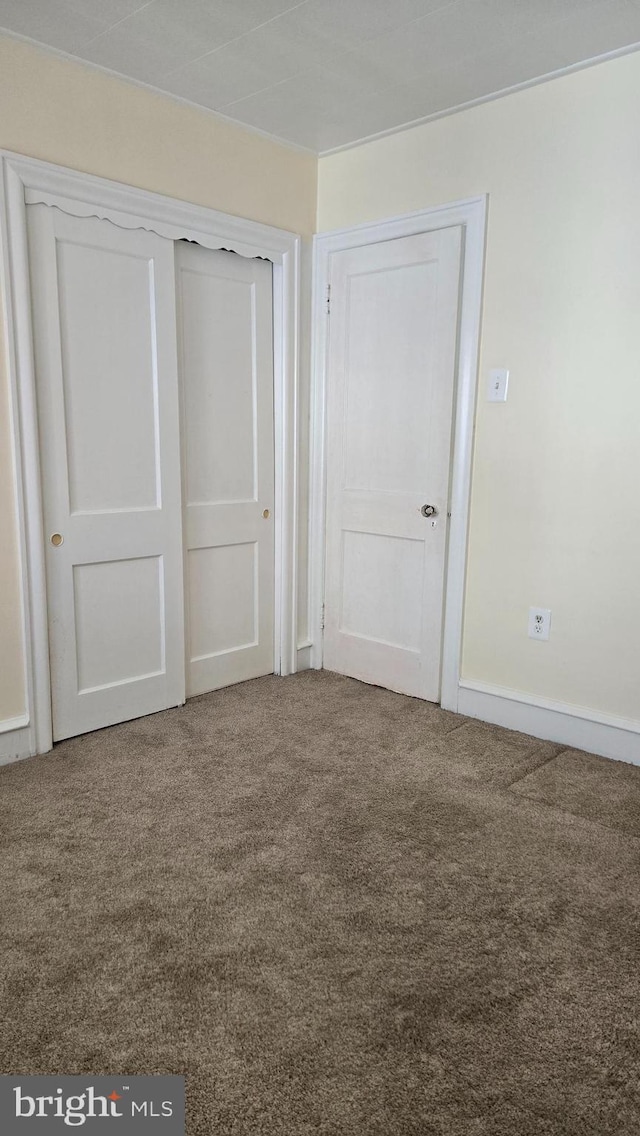 unfurnished bedroom featuring carpet and a closet