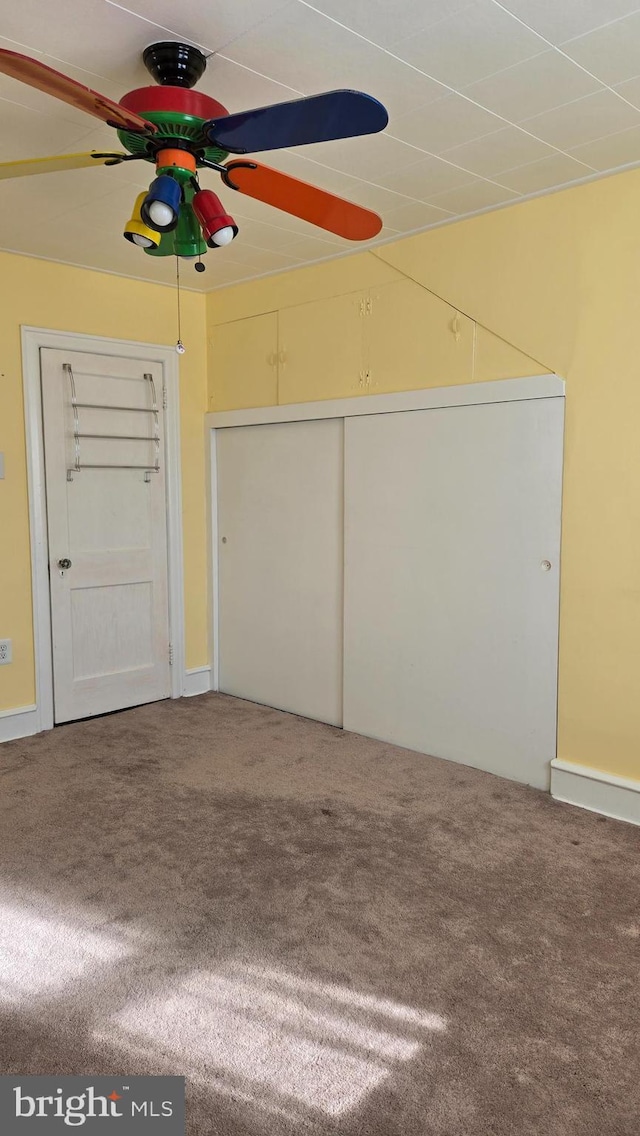 interior space featuring ceiling fan and carpet