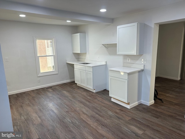 kitchen featuring white cabinetry, dark hardwood / wood-style floors, and sink