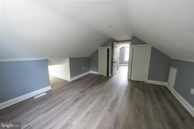 additional living space featuring lofted ceiling and wood-type flooring