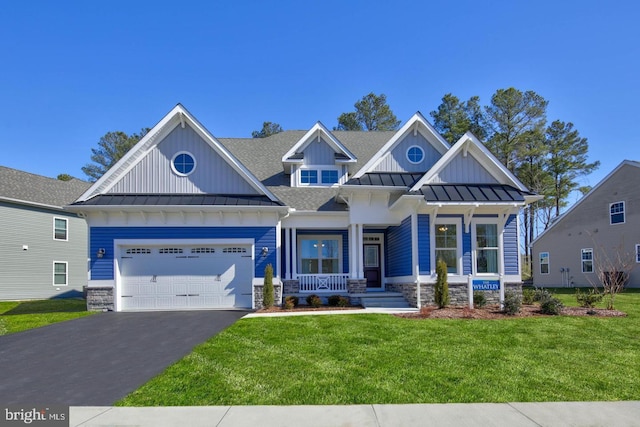 craftsman-style house featuring covered porch, a front lawn, and a garage