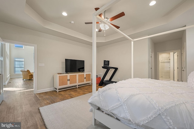 bedroom featuring a tray ceiling, hardwood / wood-style floors, and ceiling fan