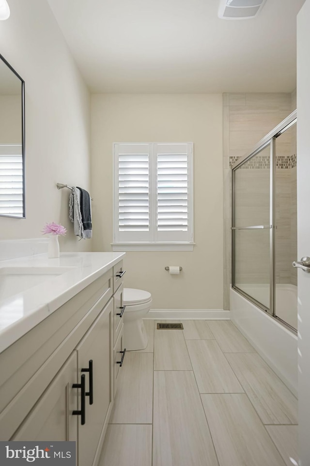 full bathroom with vanity, combined bath / shower with glass door, and toilet