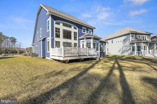 back of property with a wooden deck, cooling unit, and a lawn