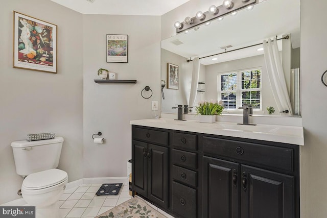 full bath with tile patterned floors, double vanity, toilet, a sink, and baseboards