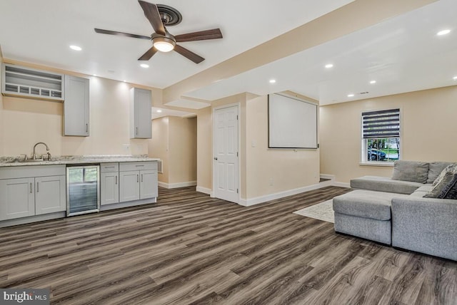living area with dark wood-style floors, baseboards, recessed lighting, a ceiling fan, and beverage cooler
