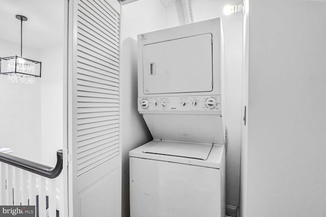 washroom featuring stacked washer and clothes dryer