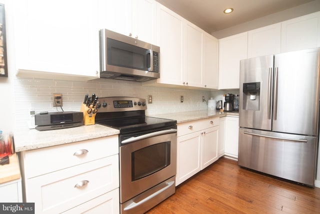 kitchen featuring appliances with stainless steel finishes, white cabinets, and tasteful backsplash