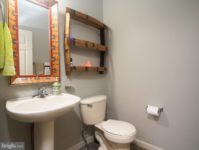 half bath with toilet and baseboards