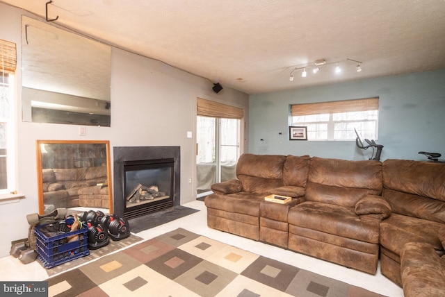 living room featuring a fireplace with flush hearth and a textured ceiling