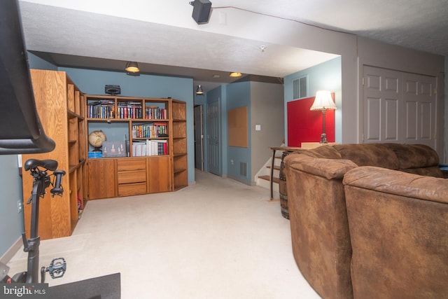 living area with baseboards, visible vents, and light colored carpet