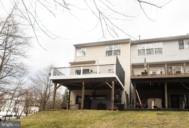 back of house with a deck and a lawn