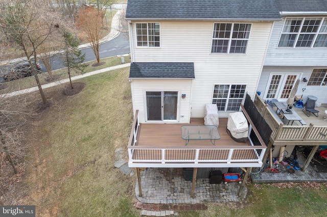 back of house featuring a yard, roof with shingles, a patio area, and a wooden deck