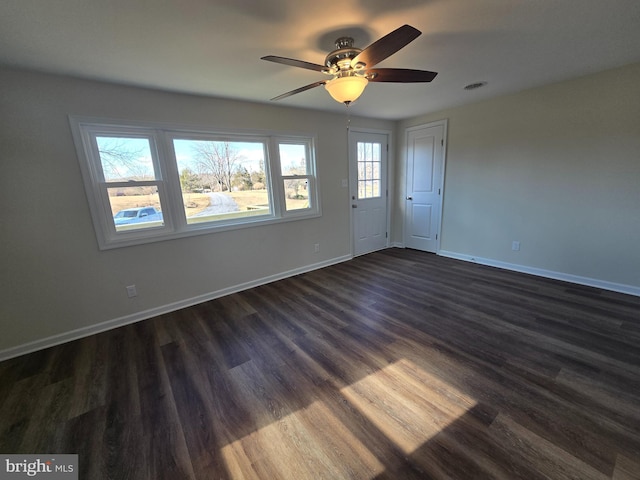 spare room featuring dark wood-type flooring and ceiling fan