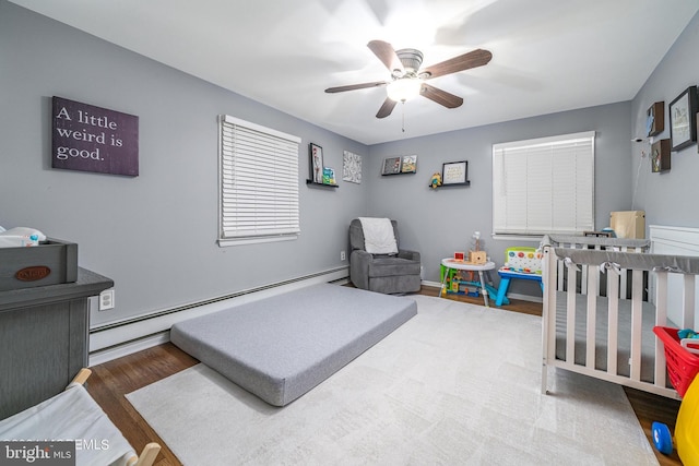 bedroom with hardwood / wood-style flooring, ceiling fan, and baseboard heating