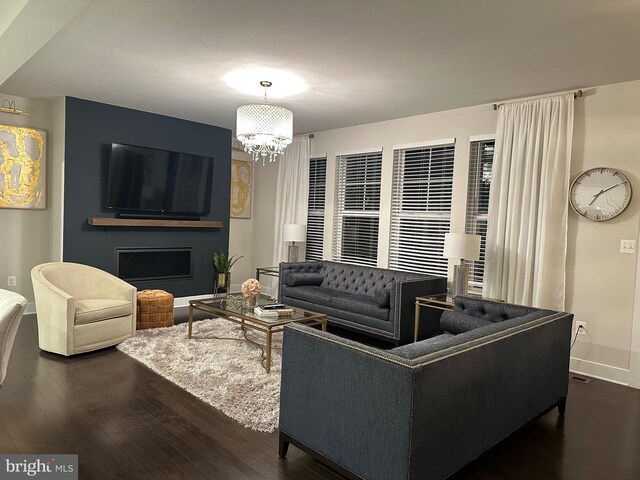 living room with baseboards, a fireplace, a chandelier, and dark wood-type flooring