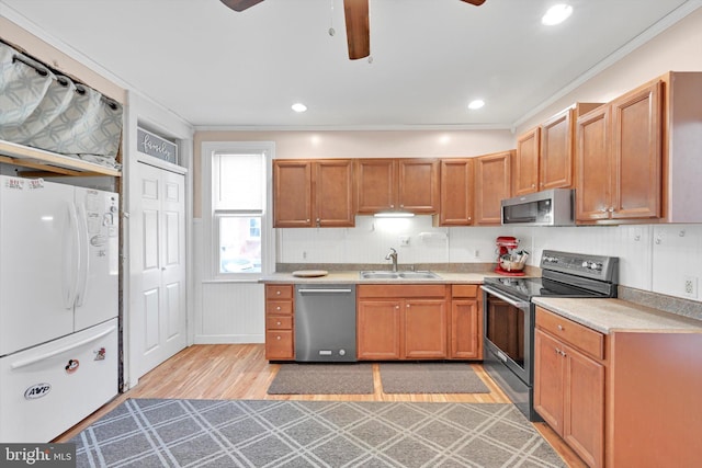 kitchen featuring crown molding, ceiling fan, appliances with stainless steel finishes, and a sink