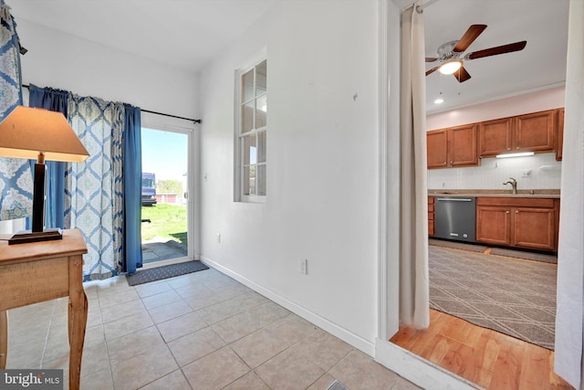entryway with baseboards, ceiling fan, and light tile patterned floors