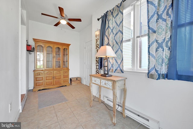 entrance foyer featuring a baseboard radiator, ceiling fan, and light tile patterned floors