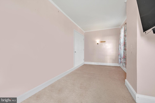 spare room featuring baseboards, ornamental molding, and carpet