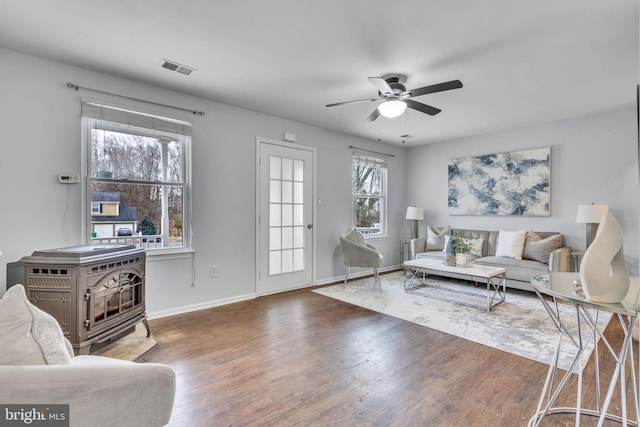 living area with baseboards, ceiling fan, visible vents, and dark wood-type flooring