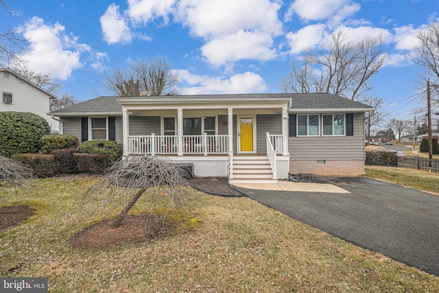 ranch-style home featuring covered porch and a front lawn