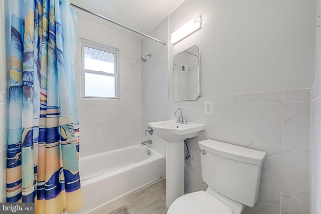 bathroom featuring hardwood / wood-style floors, shower / bath combo with shower curtain, tile walls, and toilet