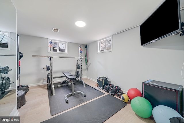 exercise room with light hardwood / wood-style flooring