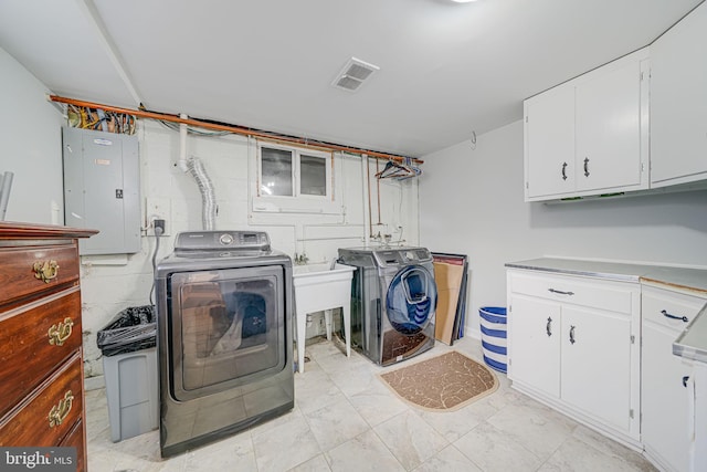 laundry area featuring cabinets, electric panel, and washer and clothes dryer