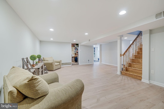 living room featuring baseboard heating and light hardwood / wood-style flooring