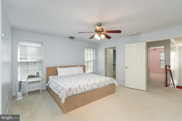 bedroom with a ceiling fan, light colored carpet, visible vents, and baseboards