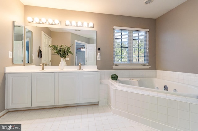 full bathroom featuring a bath, tile patterned flooring, double vanity, and a sink