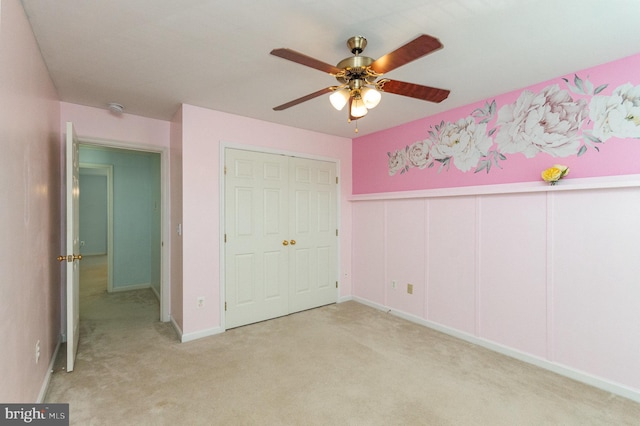 unfurnished bedroom with light carpet, ceiling fan, and a closet