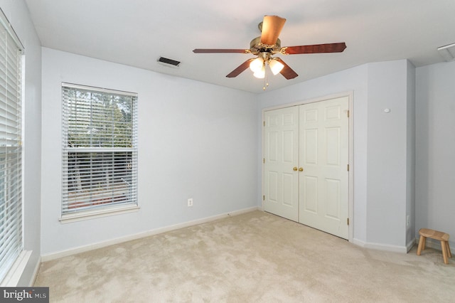 unfurnished bedroom with light colored carpet, a closet, visible vents, and baseboards